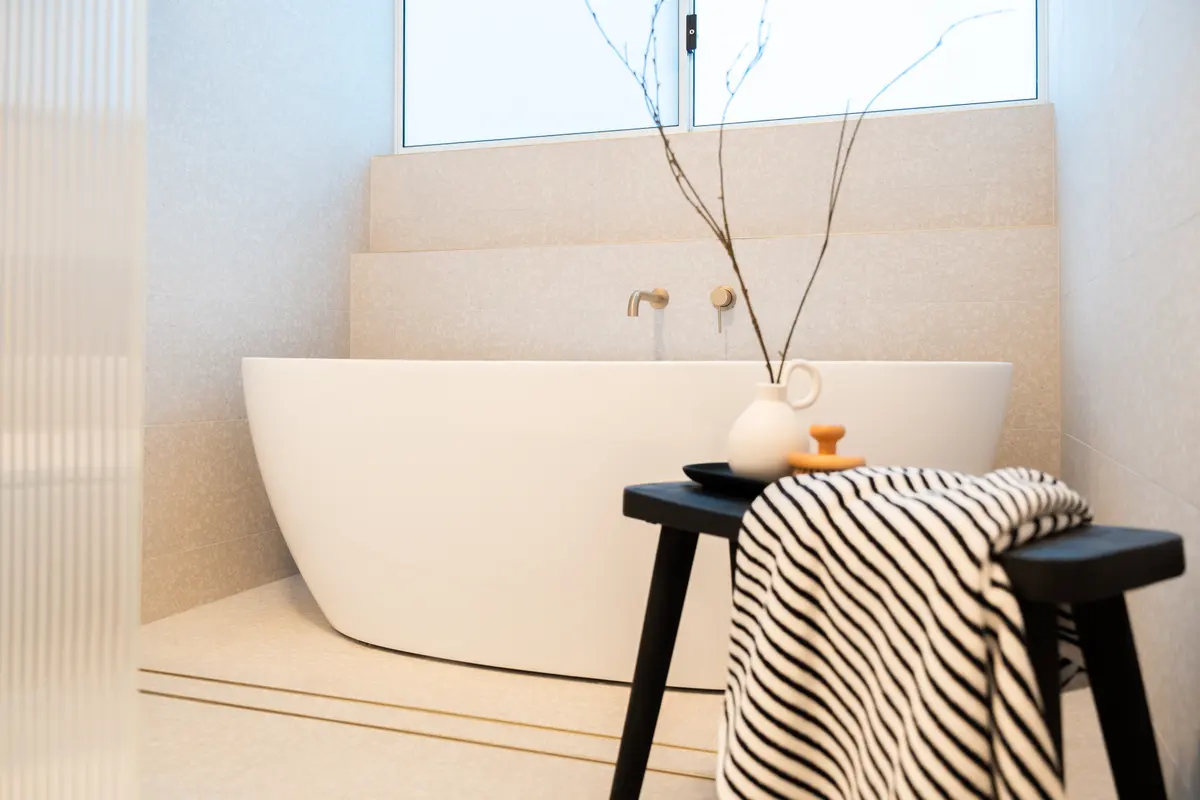 Freestanding bath: Behind reeded glass, with textured tiling.