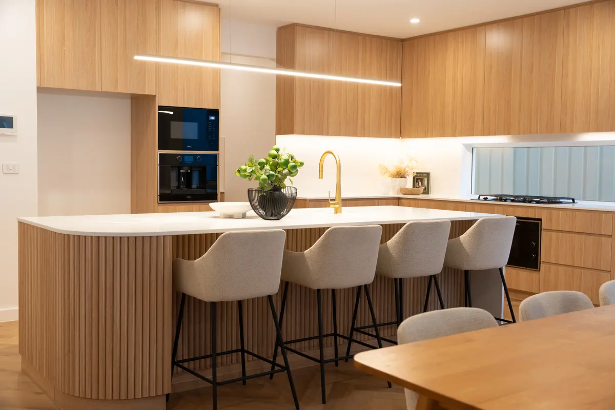 Kitchen: Island seating, integrated storage and a curved fluted island end.