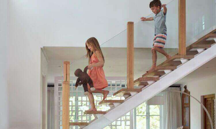 A Little Girl And A Little Boy Walking Up A Set Of Stairs