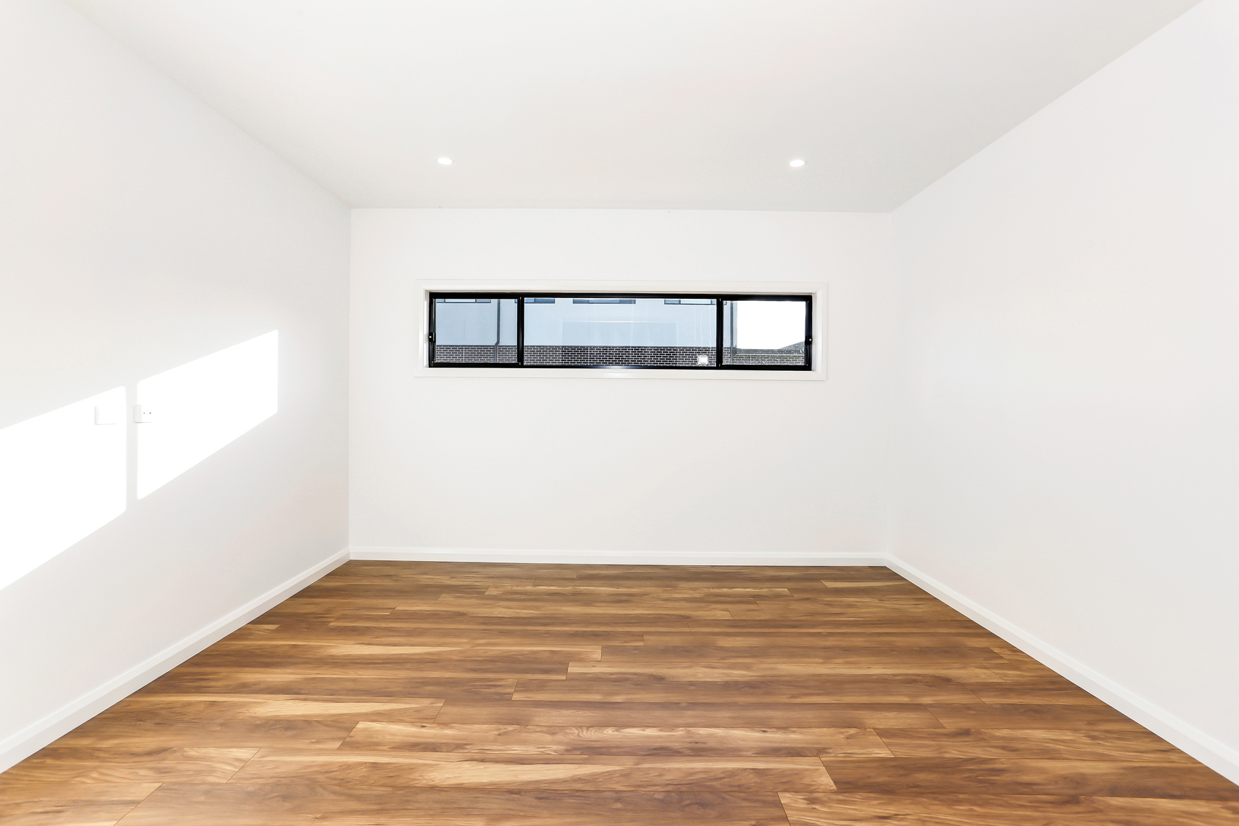 A Empty Room With A Window And Wooden Floor
