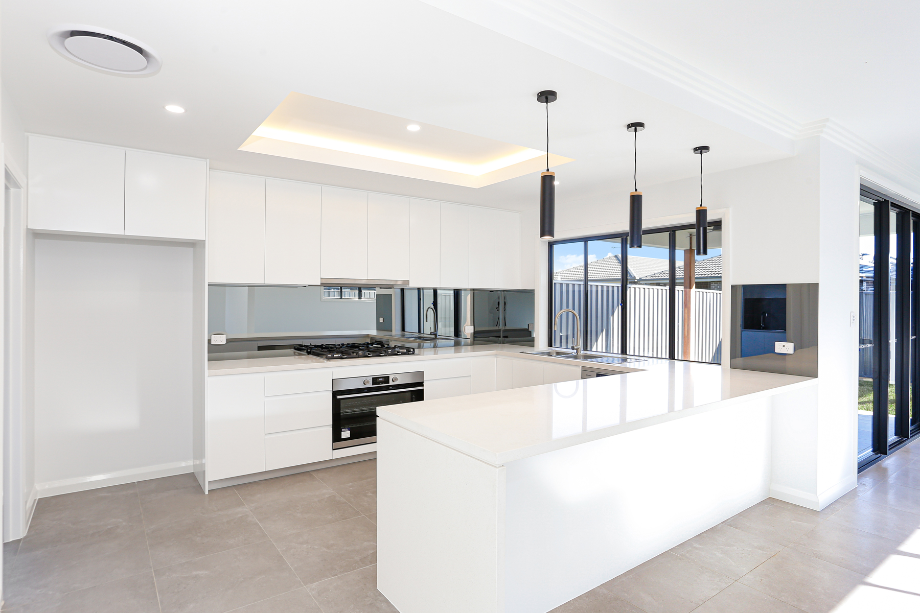 A White Kitchen With A Large Island In The Middle Of The Room