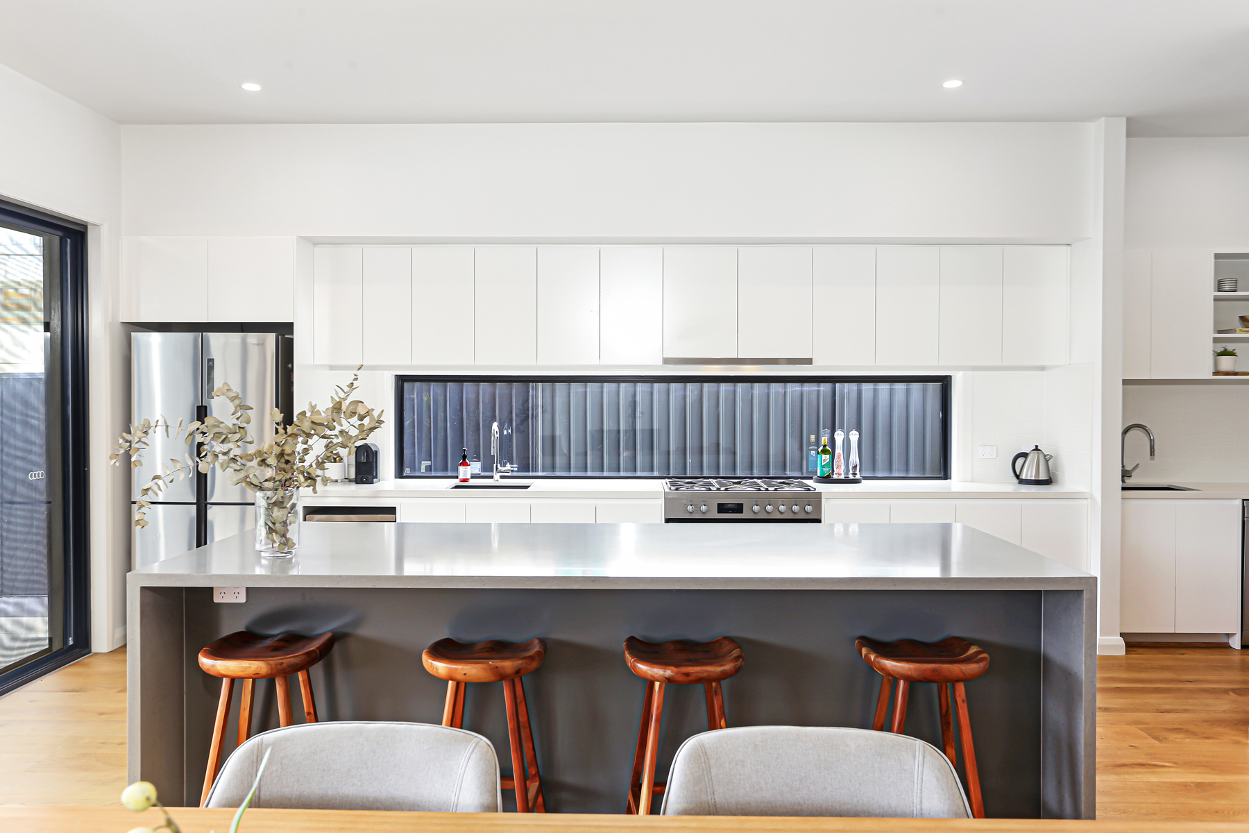 A Kitchen With A Center Island And Bar Stools