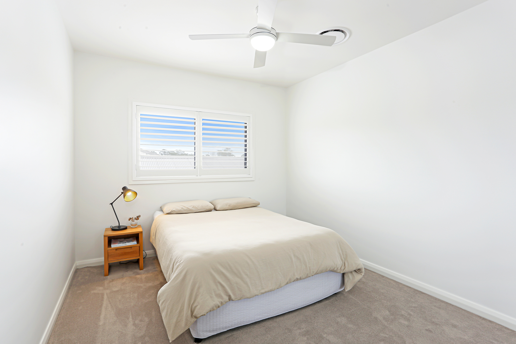 A Bedroom With A Bed And A Ceiling Fan