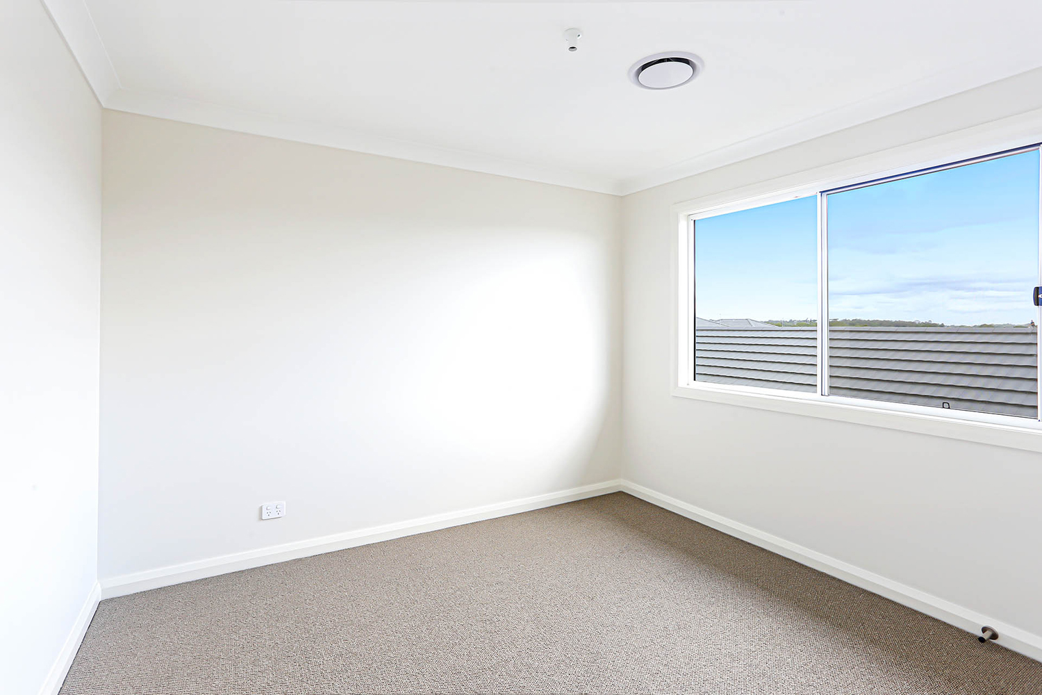 A Empty Room With A Window And Carpet