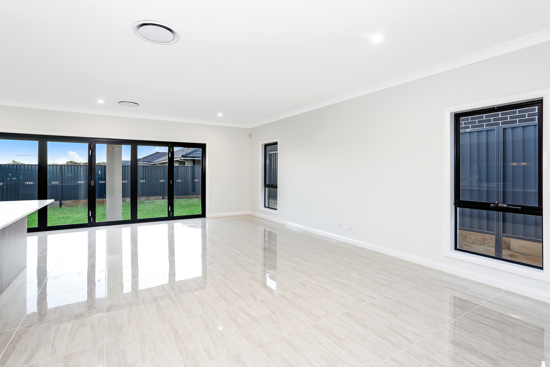 A Large Empty Living Room With Sliding Glass Doors