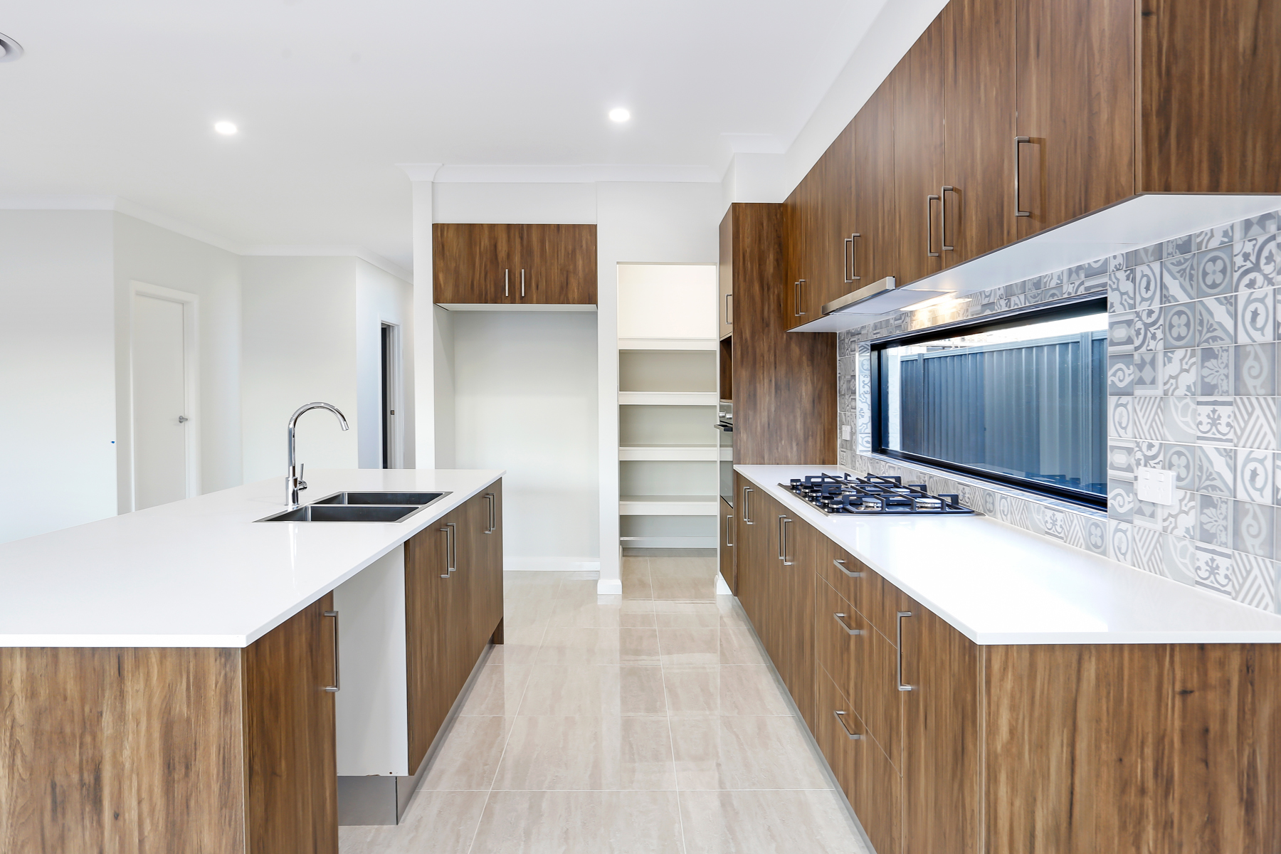 A Kitchen With Wooden Cabinets And White Countertops