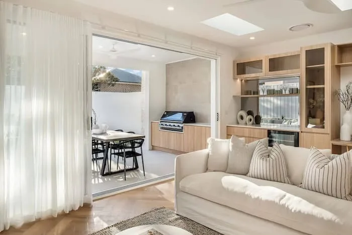 Open living area with herringbone floor and outdoor dining access