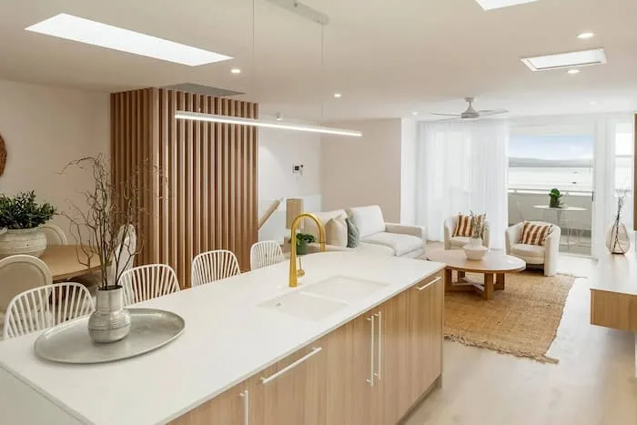 Open-concept space with kitchen island, dining set, and ocean view