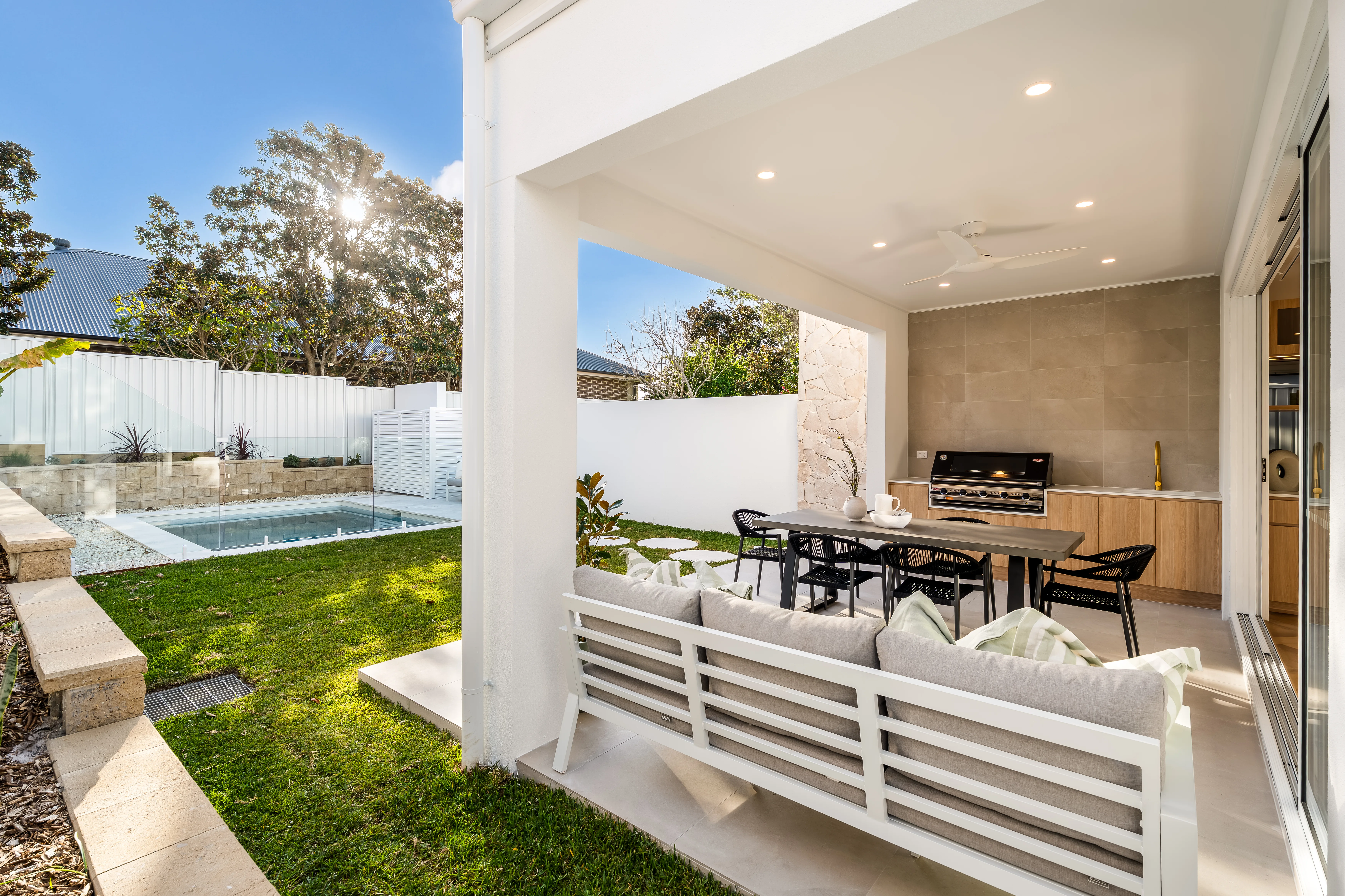 Modern patio with pool, dining area, and outdoor lounge setup