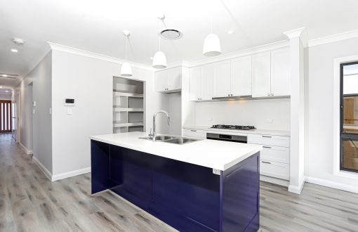 A Kitchen With White Cabinets And A Blue Island