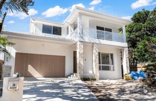 Modern two-story home with stone accents and wood garage door