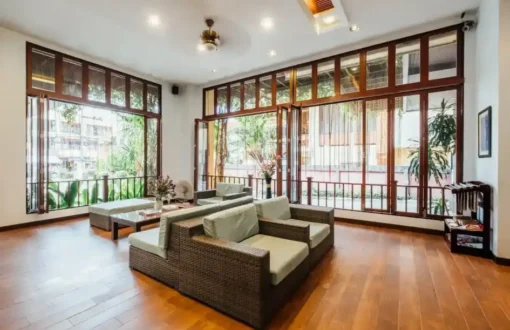 Bright living room with large windows and wicker furniture